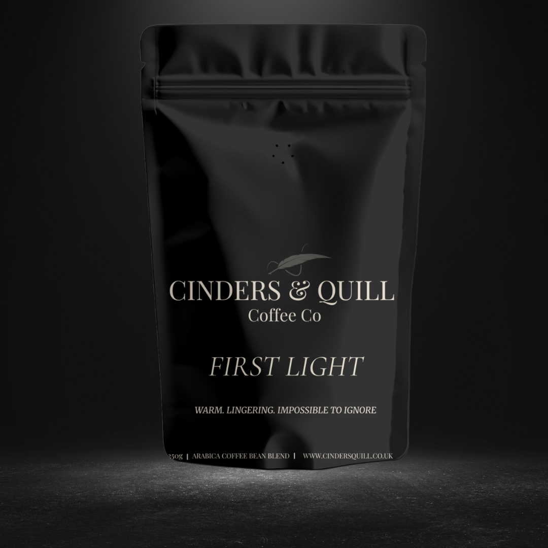 Black coffee bag from Cinders & Quill Coffee Co on a dark background