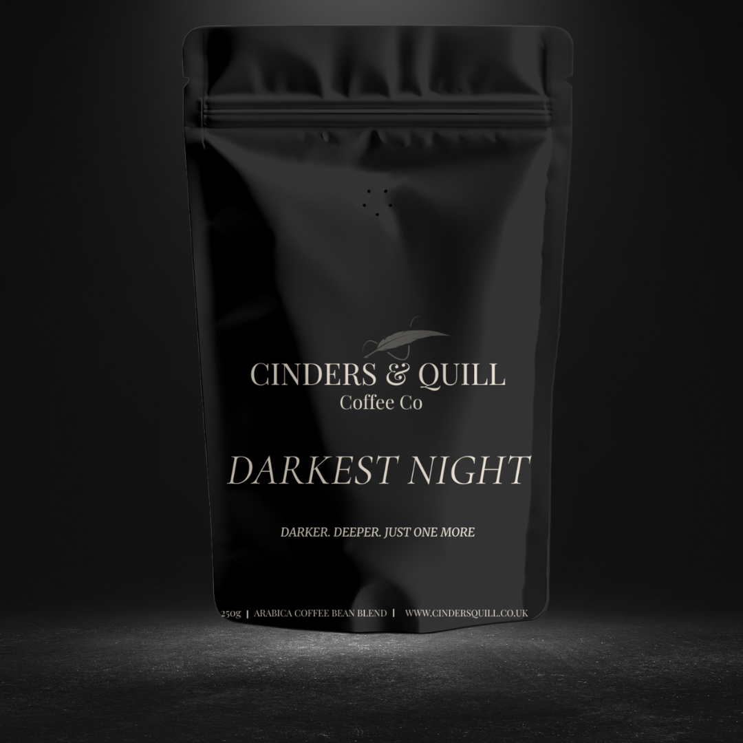 Black coffee packaging with 'Cinders & Quill Coffee Co' branding on a dark background